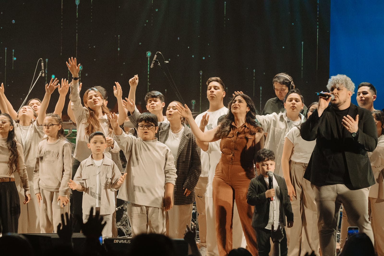 Coral de alunos da Dias Music se apresentando em grupo no palco
