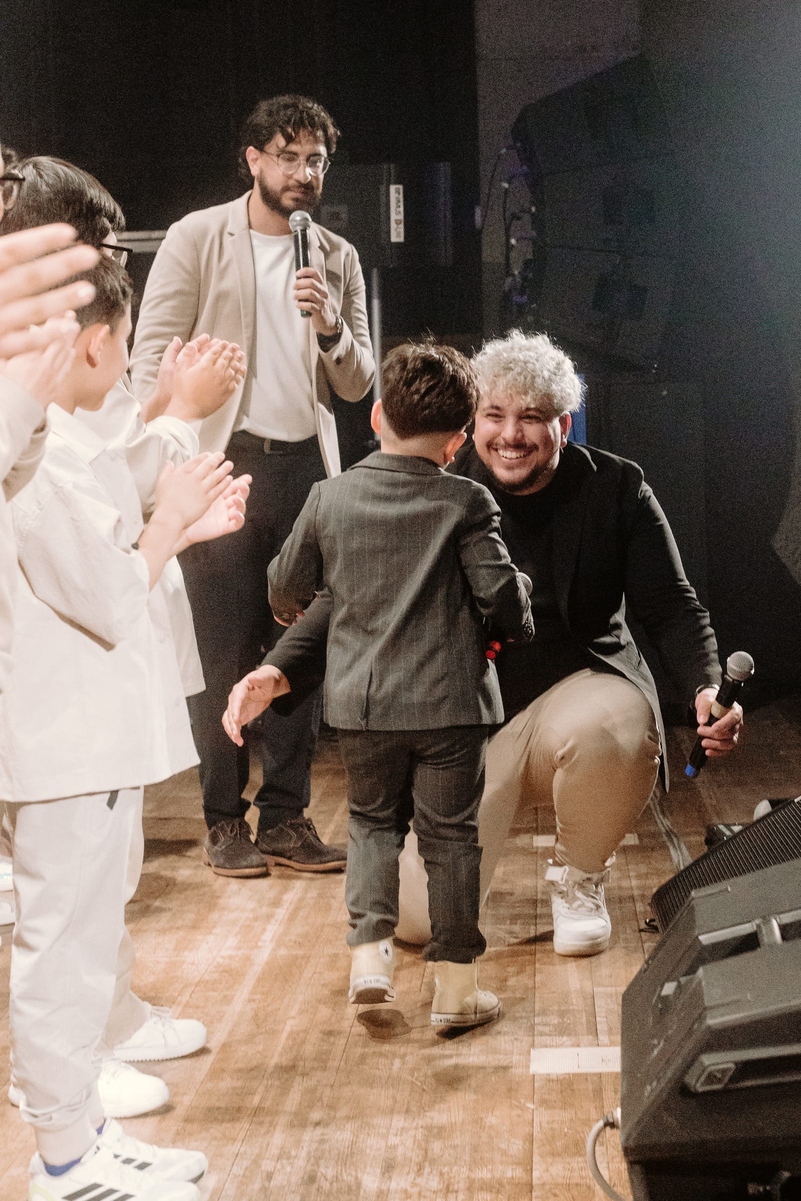Fundador da Dias Music interagindo com uma criança no palco